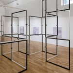 A installation view of modular sculpture comprised of 44 inch my 44 inch black and white aluminum frames stacked both horizontally and vertically.